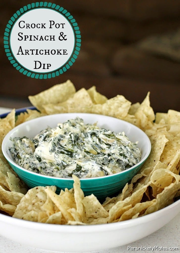 bowl of crockpot spinach artichoke dip surrounded by chips with text overlay reading "crockpot spinach & artichoke dip"