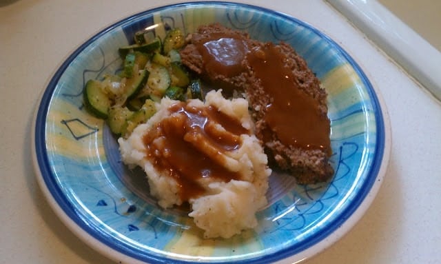 meatloaf, mashed potatoes & gravy, and zucchini on a plate