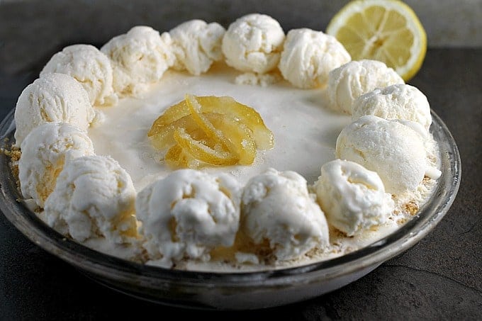 frozen lemonade pie in a glass pie dish.