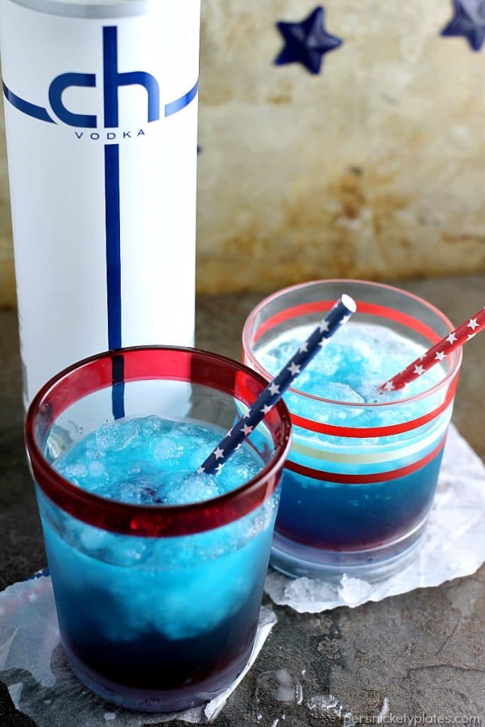 two blue cocktails with red white & blue straws.