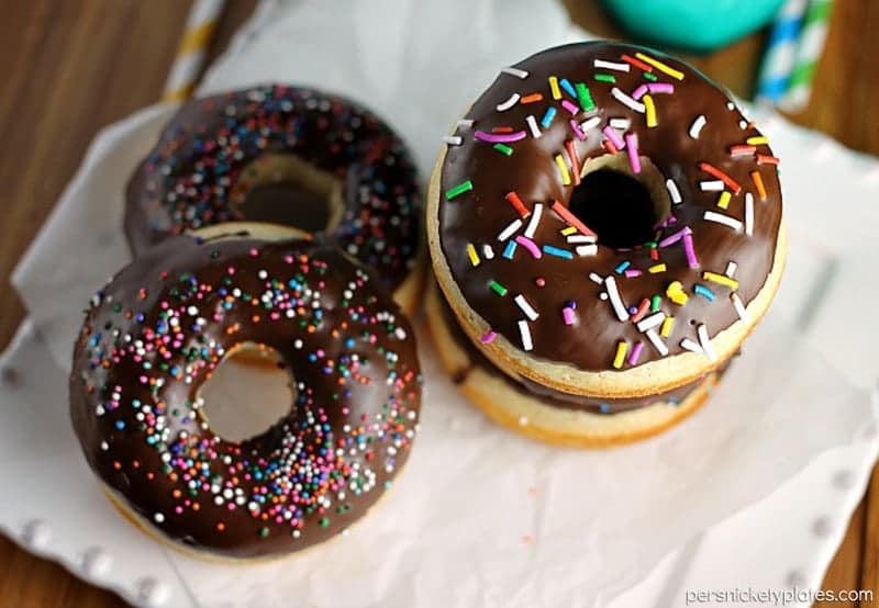 Chocolate Glazed Baked Cake Donuts covered in sprinkles. Homemade donuts are probably easier to make than you think and you can save a trip to the donut shop! | www.persnicketyplates.com