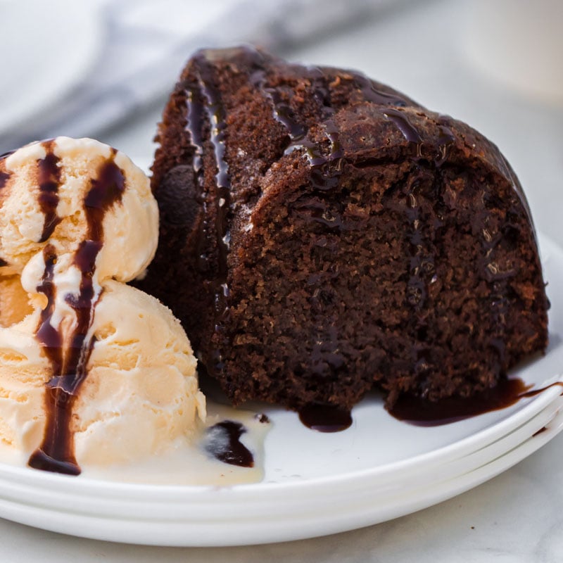 chocolate bundt cake with vanilla ice cream on white plate
