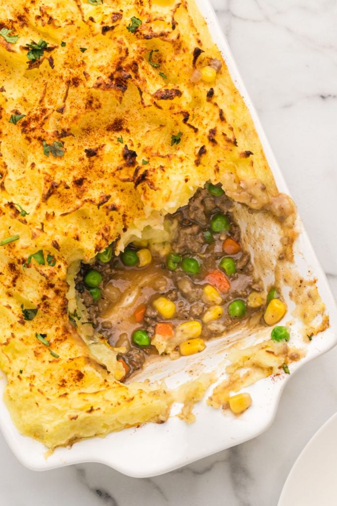 overhead shot of shepherd's pie in a casserole dish with a scoop missing