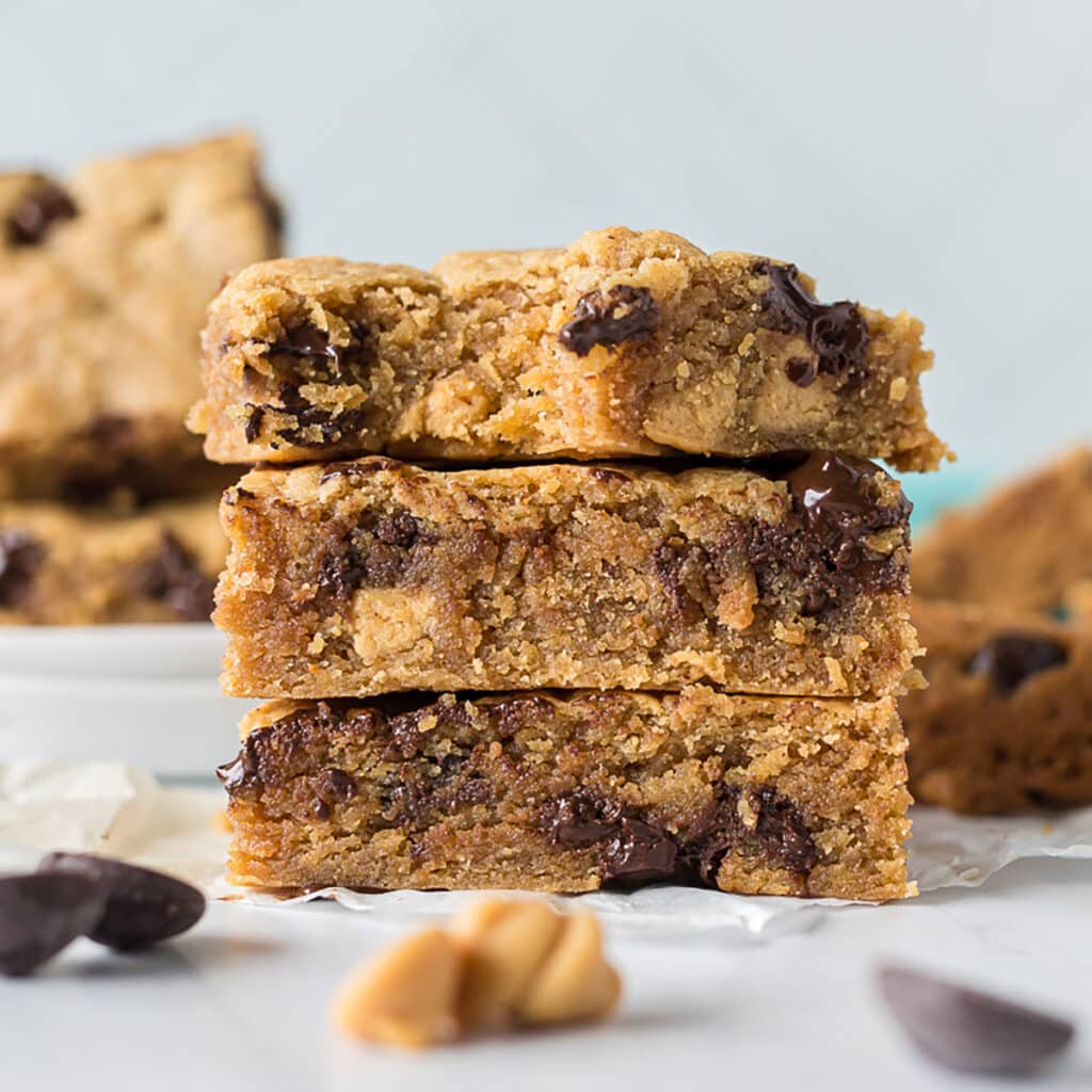 3 chocolate chip peanut butter blondies in a stack.