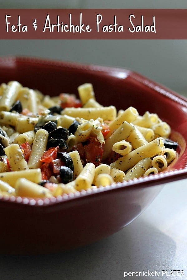 red bowl of pasta salad with feta & artichoke pasta salad text overlay