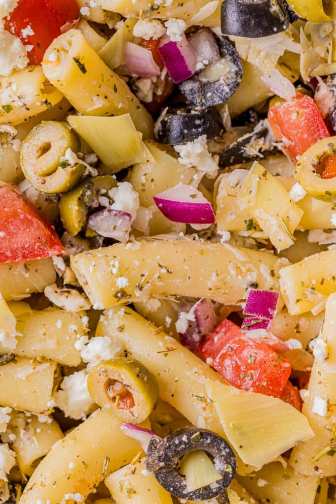 closeup of greek pasta salad with artichokes and olives.