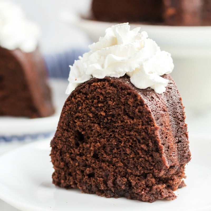 slice of williams sonoma sour cream chocolate bundt cake with whipped cream on white plate 