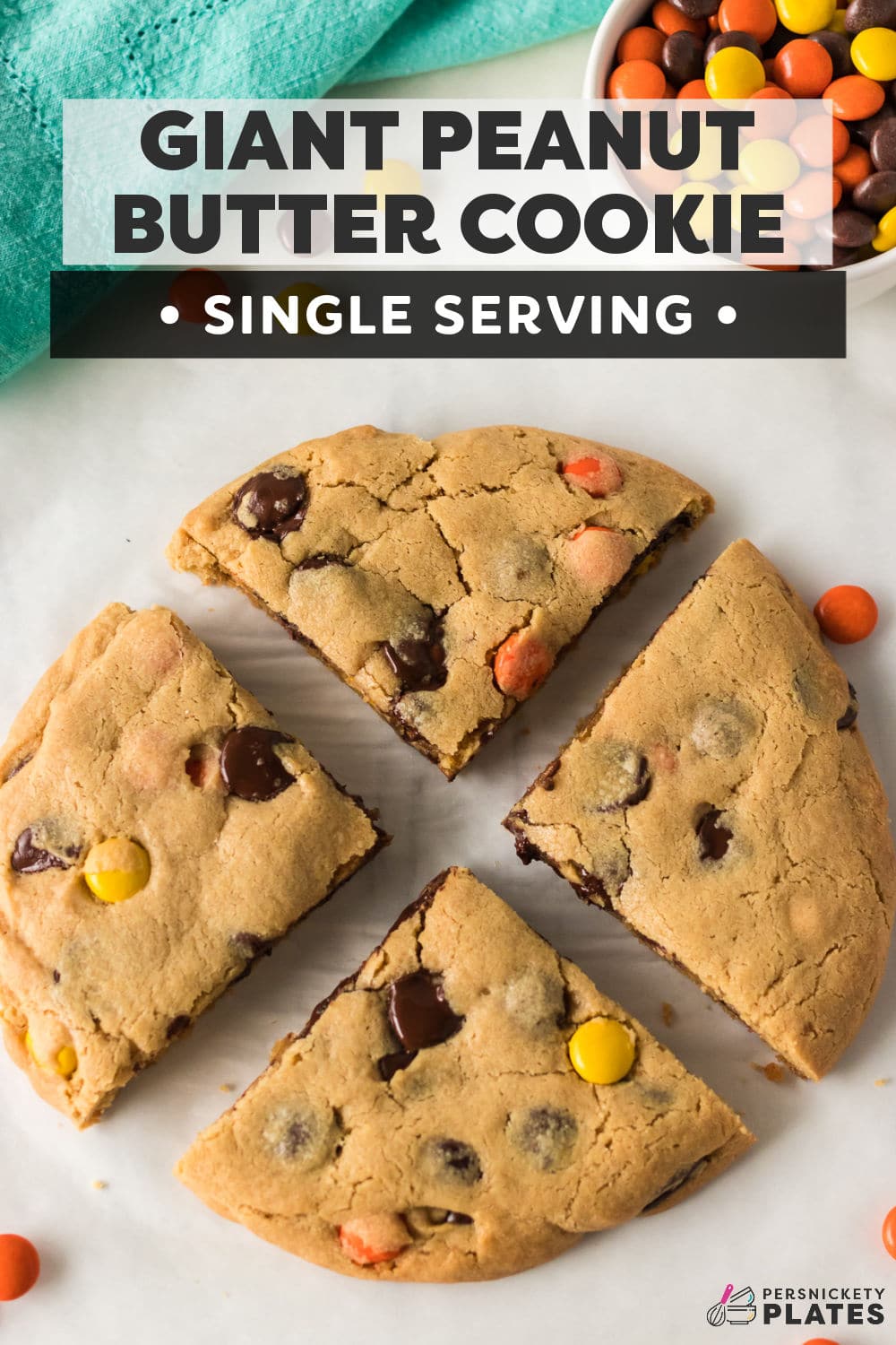 This Giant Peanut Butter Cookie is loaded with chocolate chips and Reese’s pieces in every bite and ready in 30 minutes. It’s soft in the center, chewy around the edges, and perfect for one person or two if you feel like sharing. | www.persnicketyplates.com