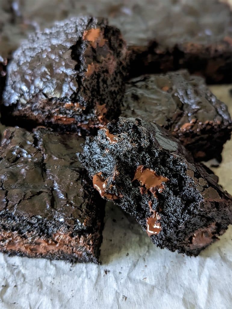 stack of dark chocolate brownies with a bite missing from one.