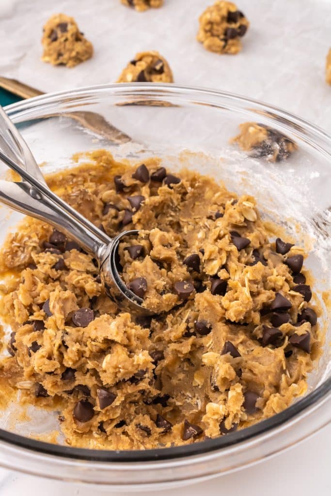 cookie scoop in a bowl of cookie dough.