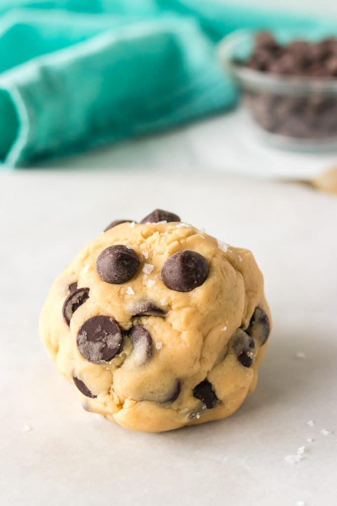 chocolate chip cookie dough ball on a baking sheet.