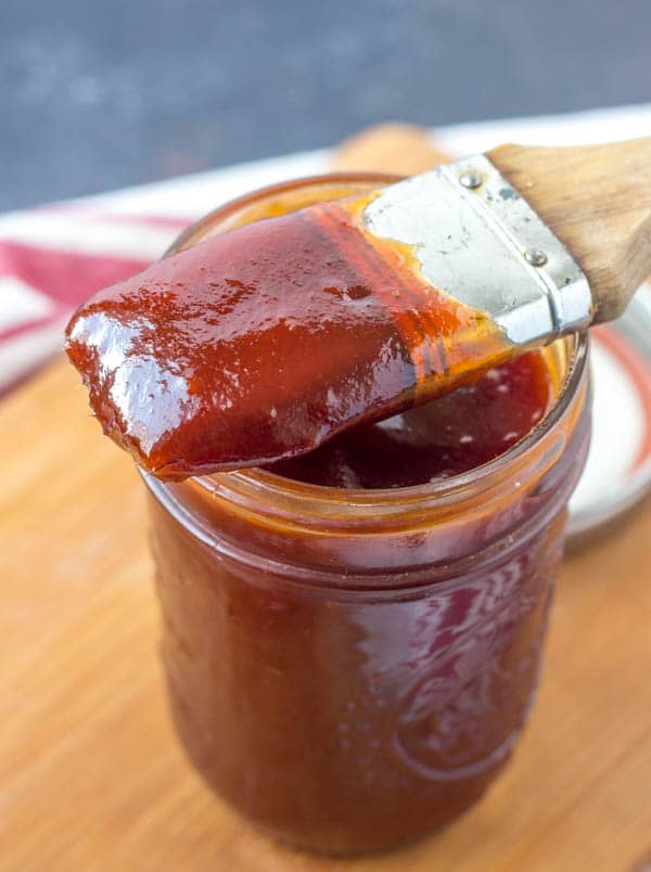 mason jar with bbq sauce covered brush resting on top