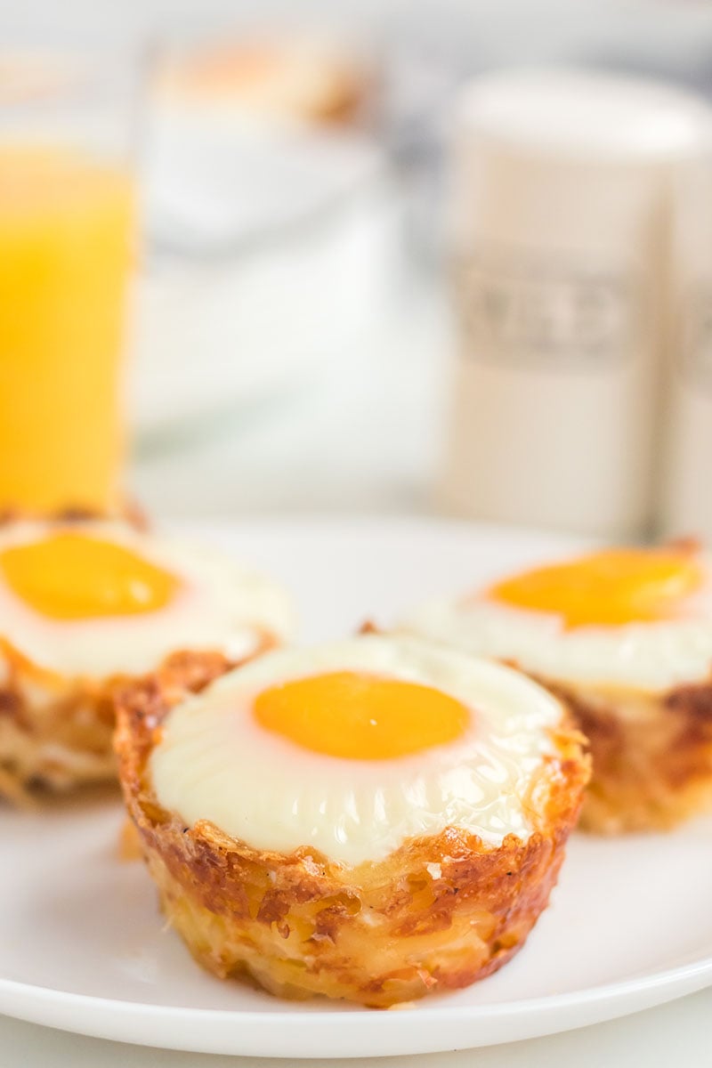 three hash brown egg cups on a white plate 
