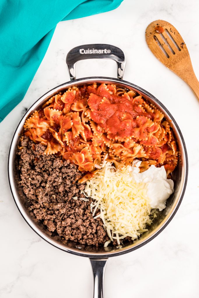 overhead shot of a skillet filled with ground beef, cheese, and pasta.