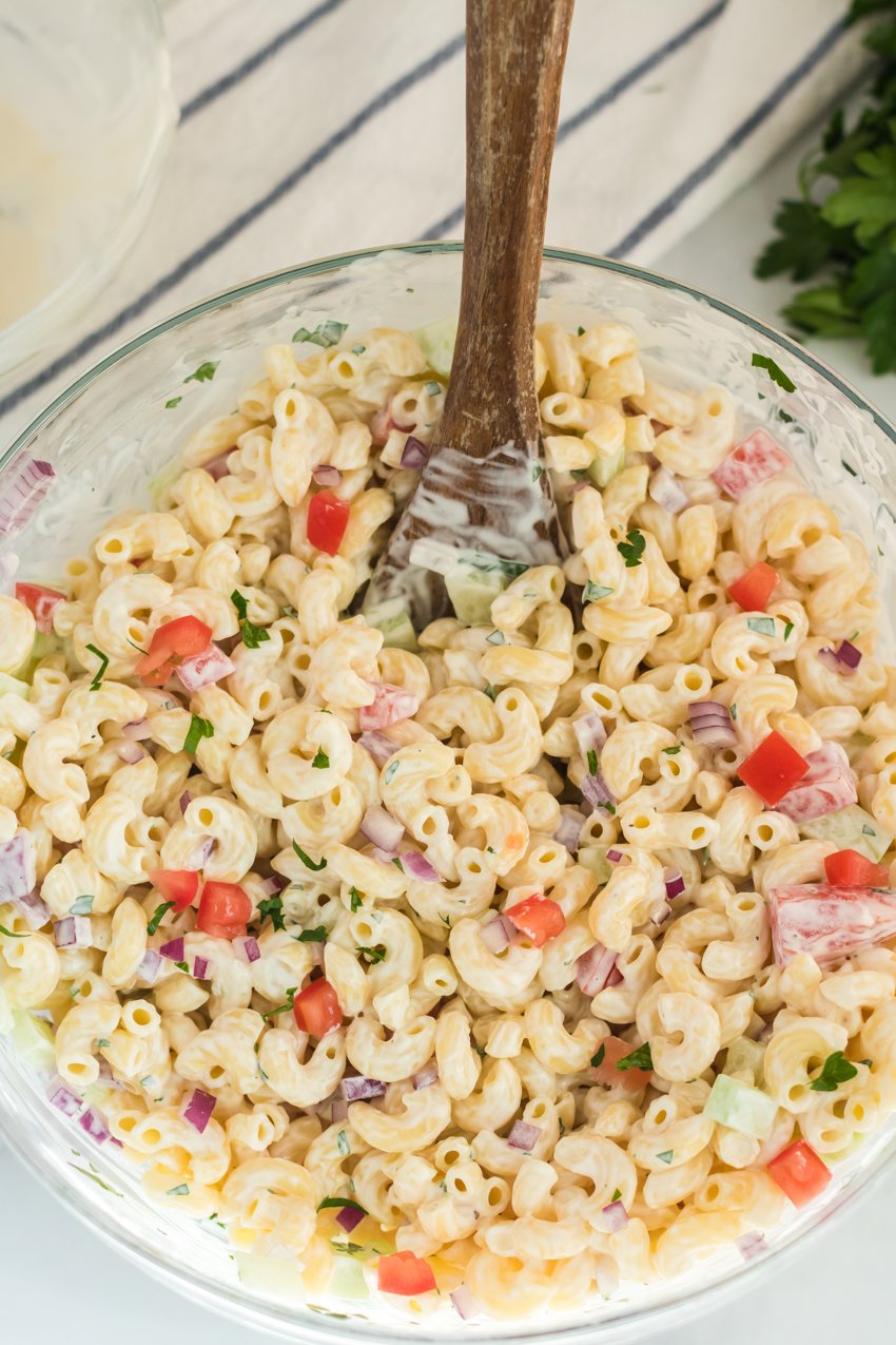 large bowl of macaroni salad with wooden spoon