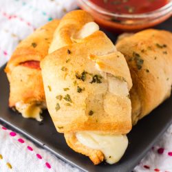 crescent roll pepperoni pizza roll-ups on a grey plate.