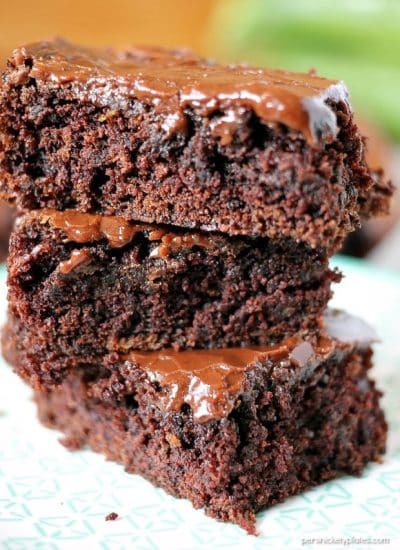 Zucchini Brownies are moist and chocolaty with a simple frosting. They also happen to be dairy-free/vegan. You'll never know there's zucchini hidden in them! | www.persnicketyplates.com