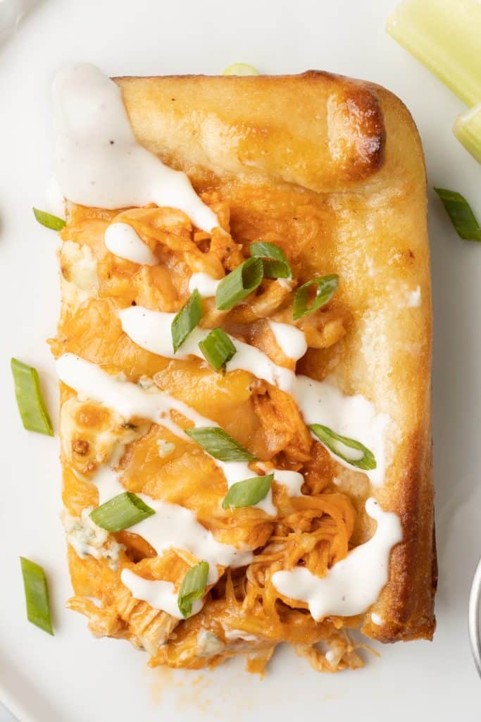 slice of buffalo chicken pizza drizzled with ranch dressing.