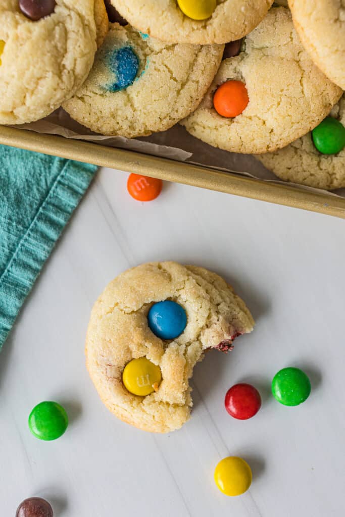 sugar butter M&M cookie with a bite missing.