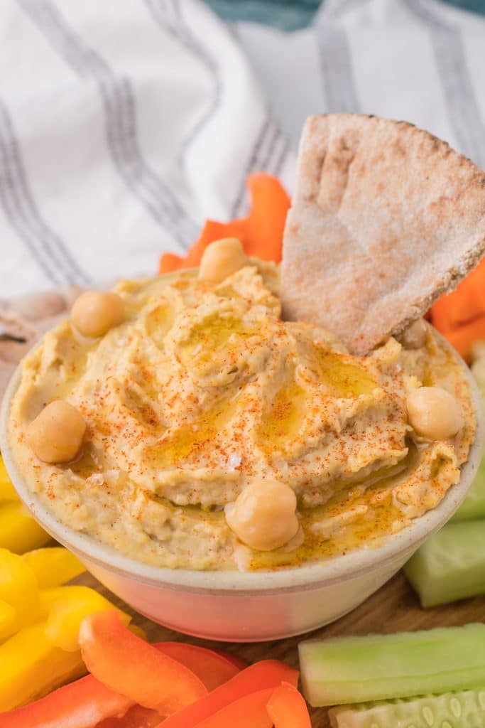 bowl of hummus with a piece of pita bread.