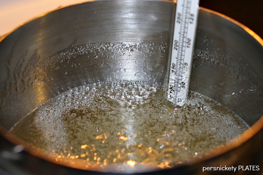sugar boiling in a pot with a candy thermometer