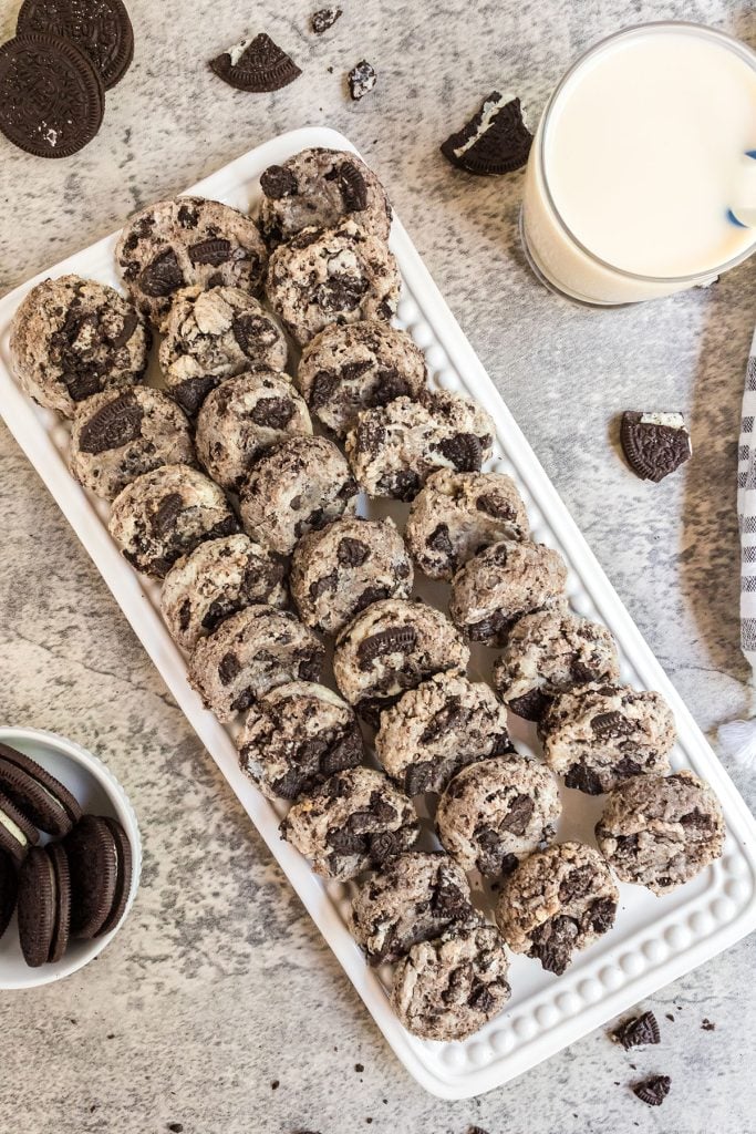 platter of cookies surrounded by oreos and a glass of milk.