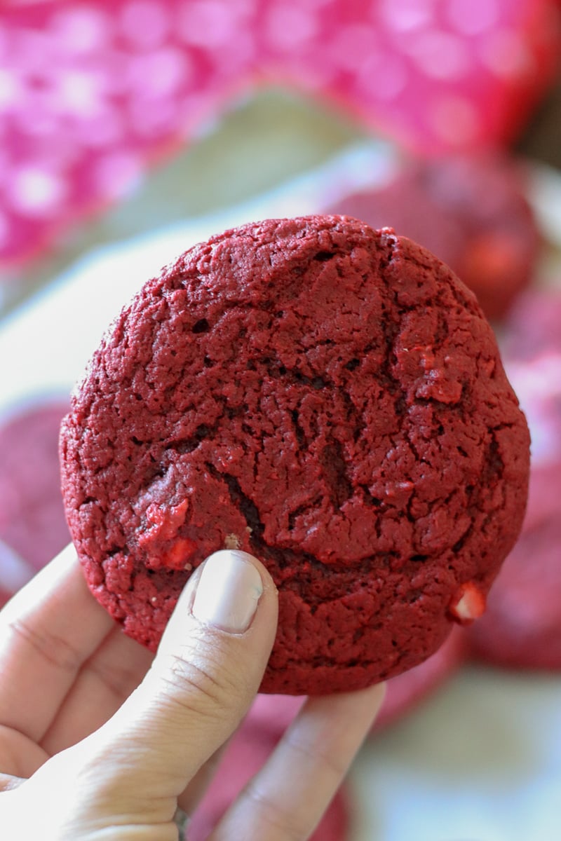 red velvet cream cheese swirl cookie held in a hand