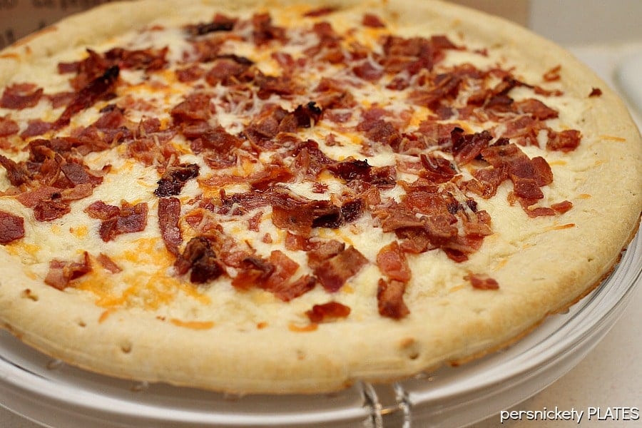 melted cheese and bacon bits on pizza crust for blt pizza