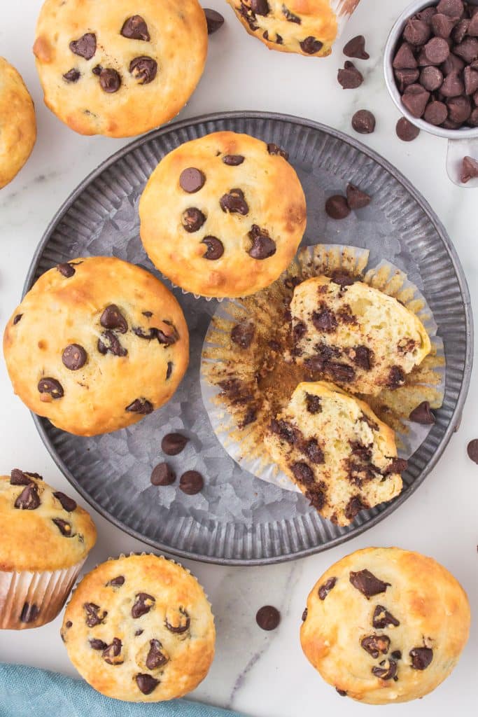 overhead shot of chocolate chip muffin cut in half on a plate.