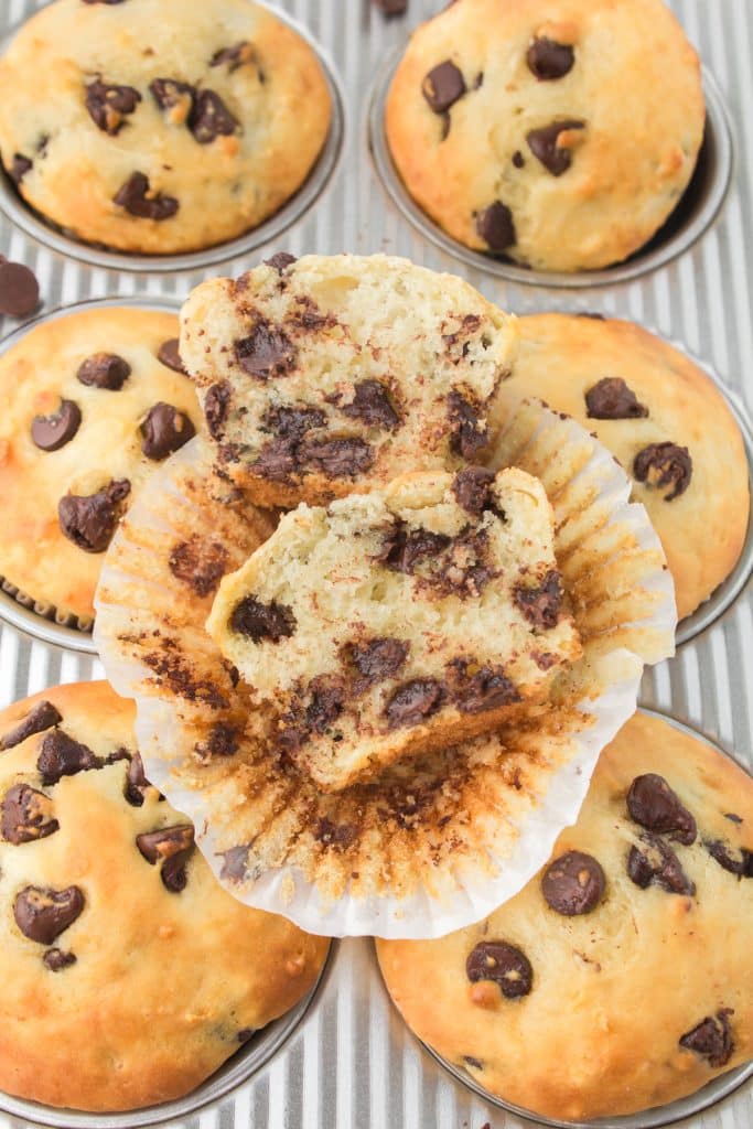 overhead shot of a chocolate chip muffin sliced in half on the wrapper.