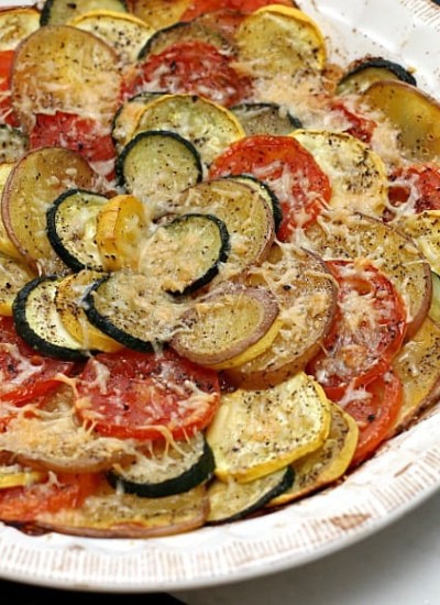 Vegetable Tian is a delicious vegetarian dish made with zucchini, squash, tomatoes, and red skin potatoes, baked together and sprinkled with cheese. This colorful vegetable recipe makes a beautiful side dish or a main vegetarian meal.