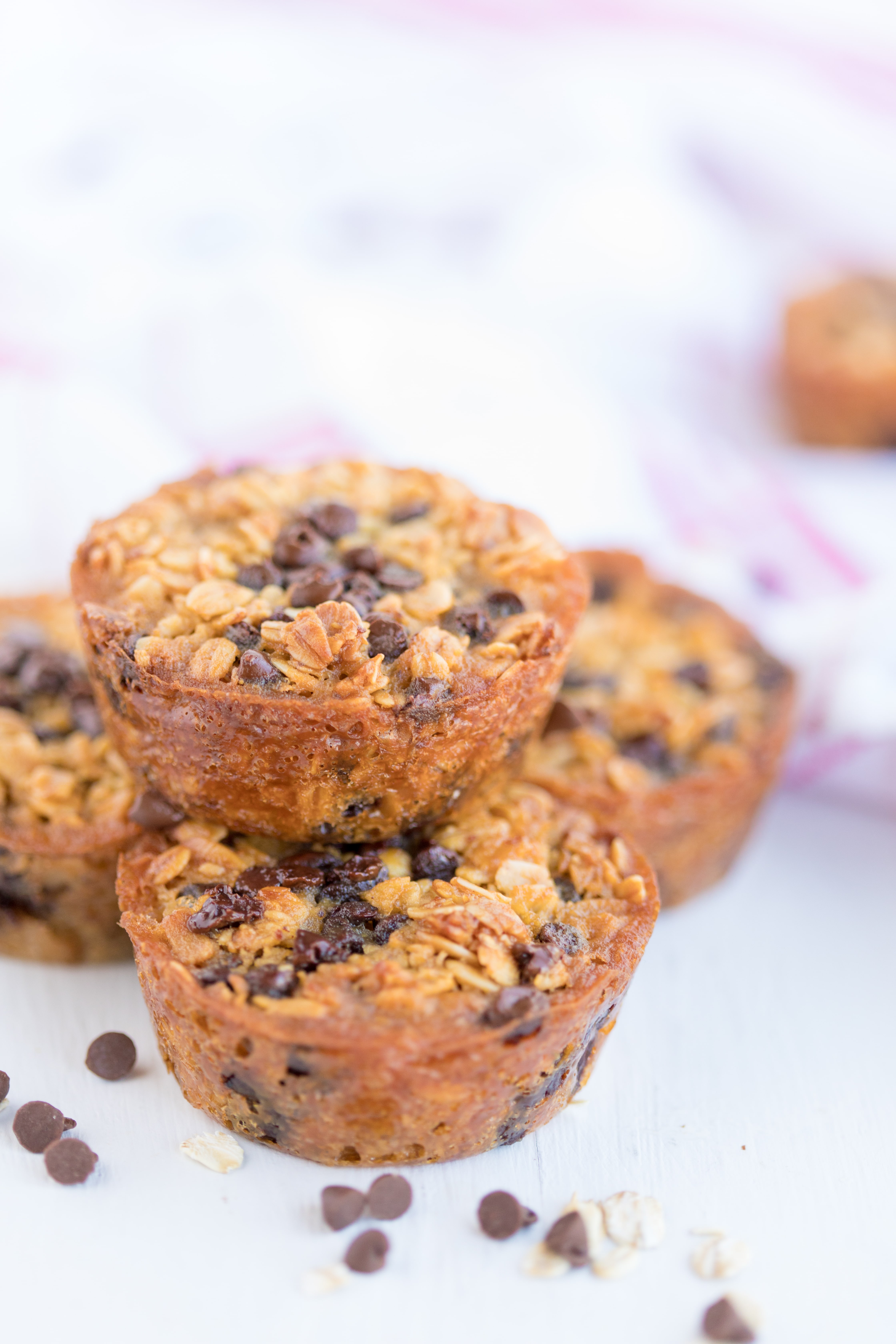 stack of 4 baked oatmeal chocolate chip breakfast cups with scattered chocolate chips