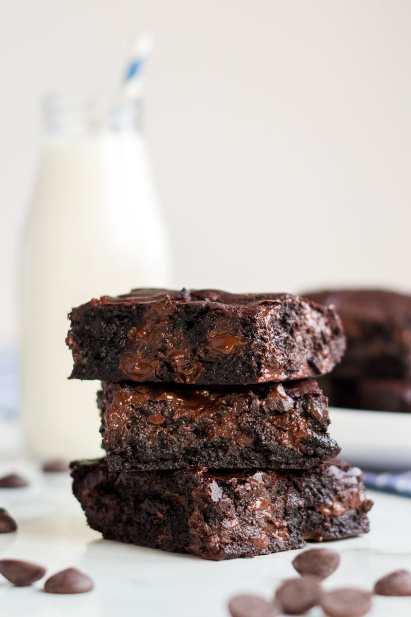 stack of 3 coconut oil brownies with milk in background 