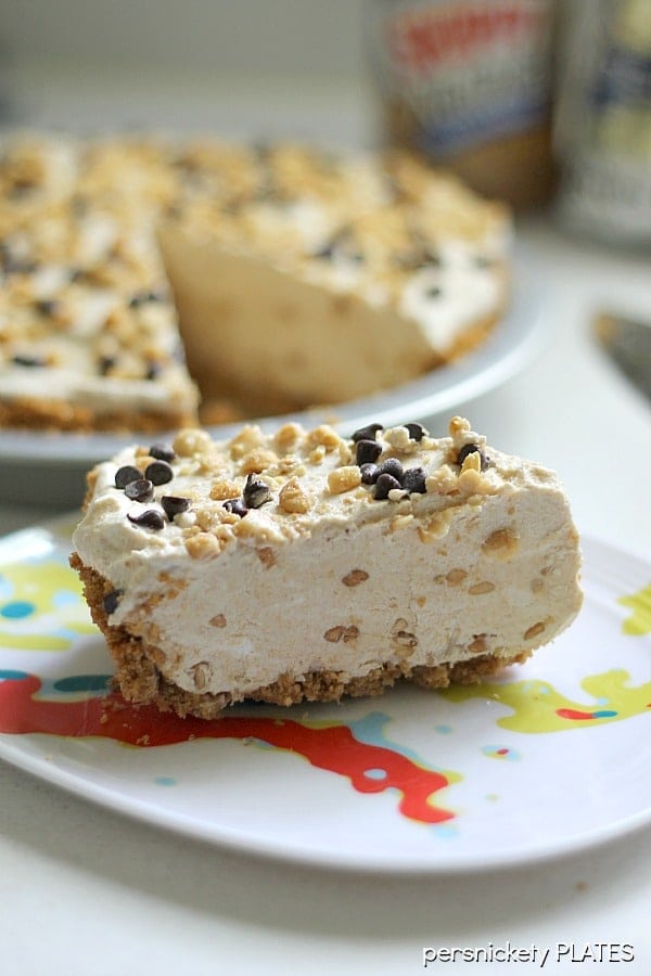 slice of peanut butter pie topped with peanuts and mini chocolate chips.