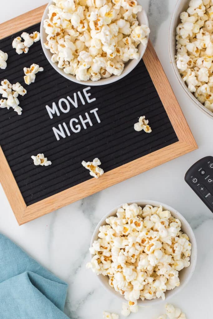 bowls of coconut oil popcorn next to a movie night letterboard.