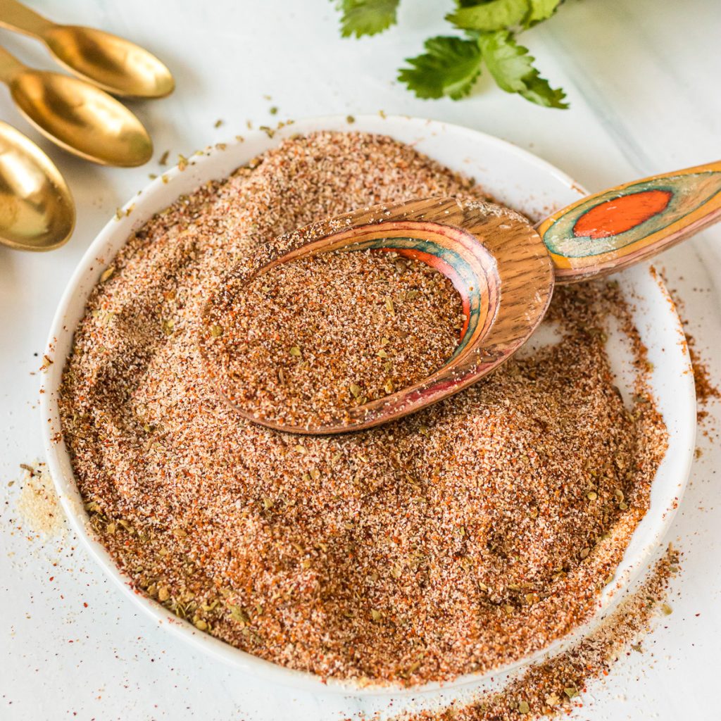 homemade taco seasoning mix with a wooden spoon scooping it