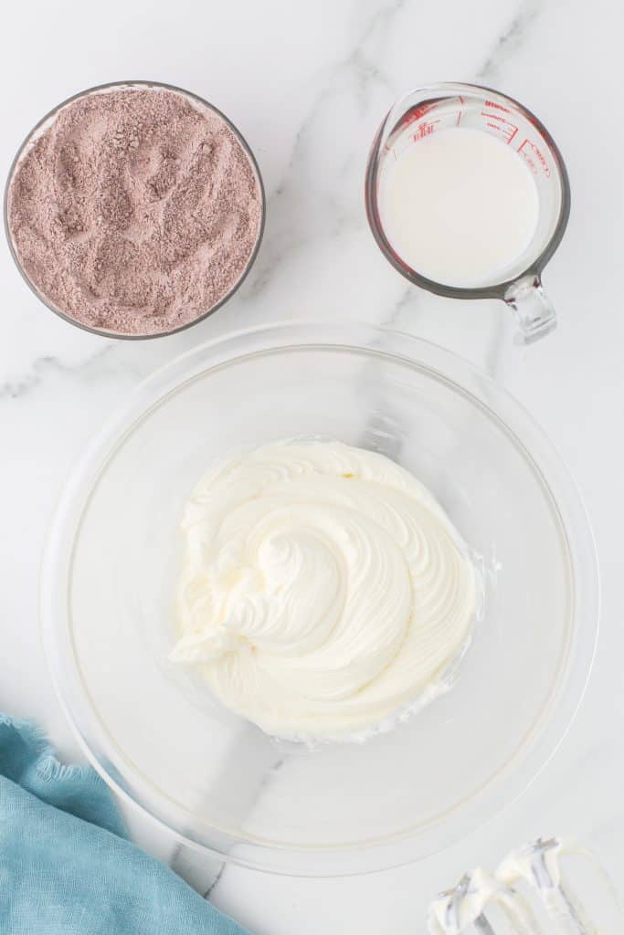 overhead shot of whipped cream cheese in a mixing bowl.