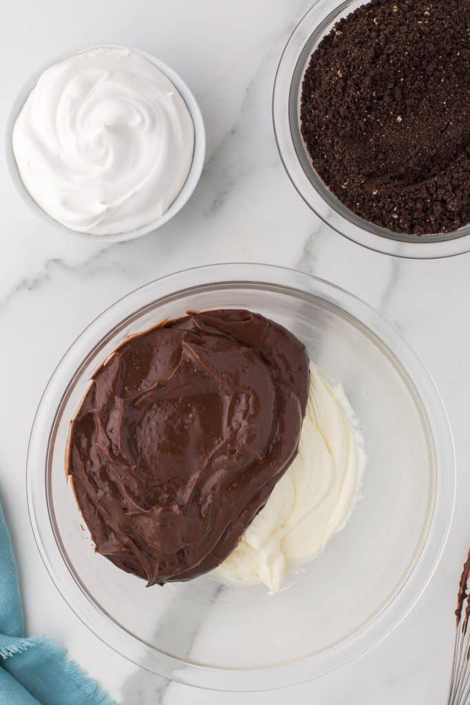 chocolate pudding in a bowl with a whipped cream cheese mixture.