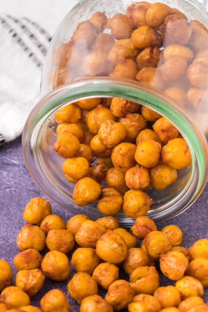 roasted chickpeas pouring out of a glass jar.