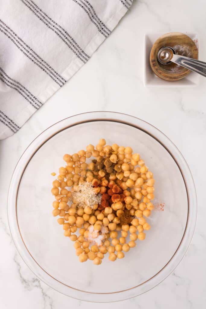 overhead shot of chickpeas and seasonings in a mixing bowl.