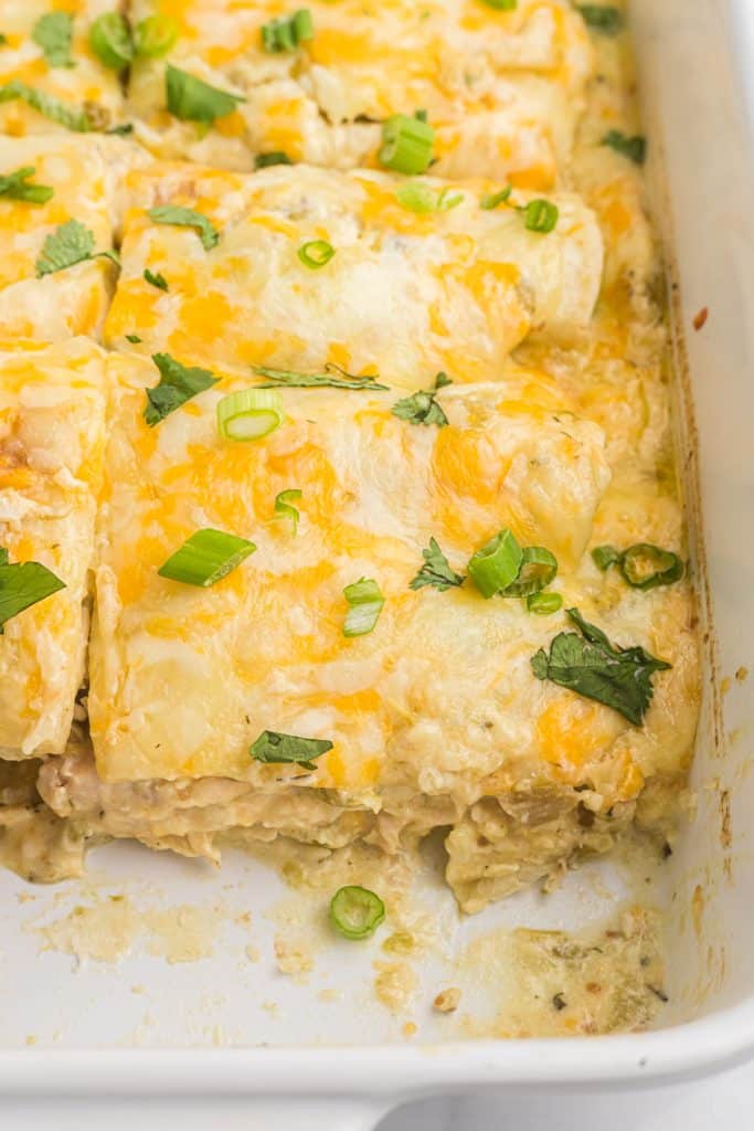 side view of a baking dish of green chicken enchiladas.
