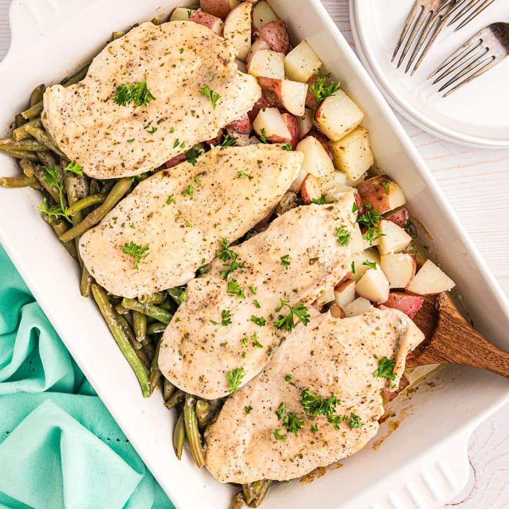 baked chicken potatoes & green beans in a baking dish.