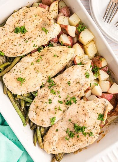 baked chicken potatoes & green beans in a baking dish.