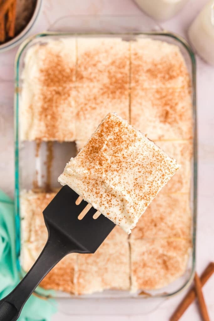 spatula lifting a slice of cake sprinkled with cinnamon.
