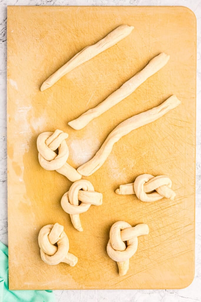 dough strips being shaped into knots.