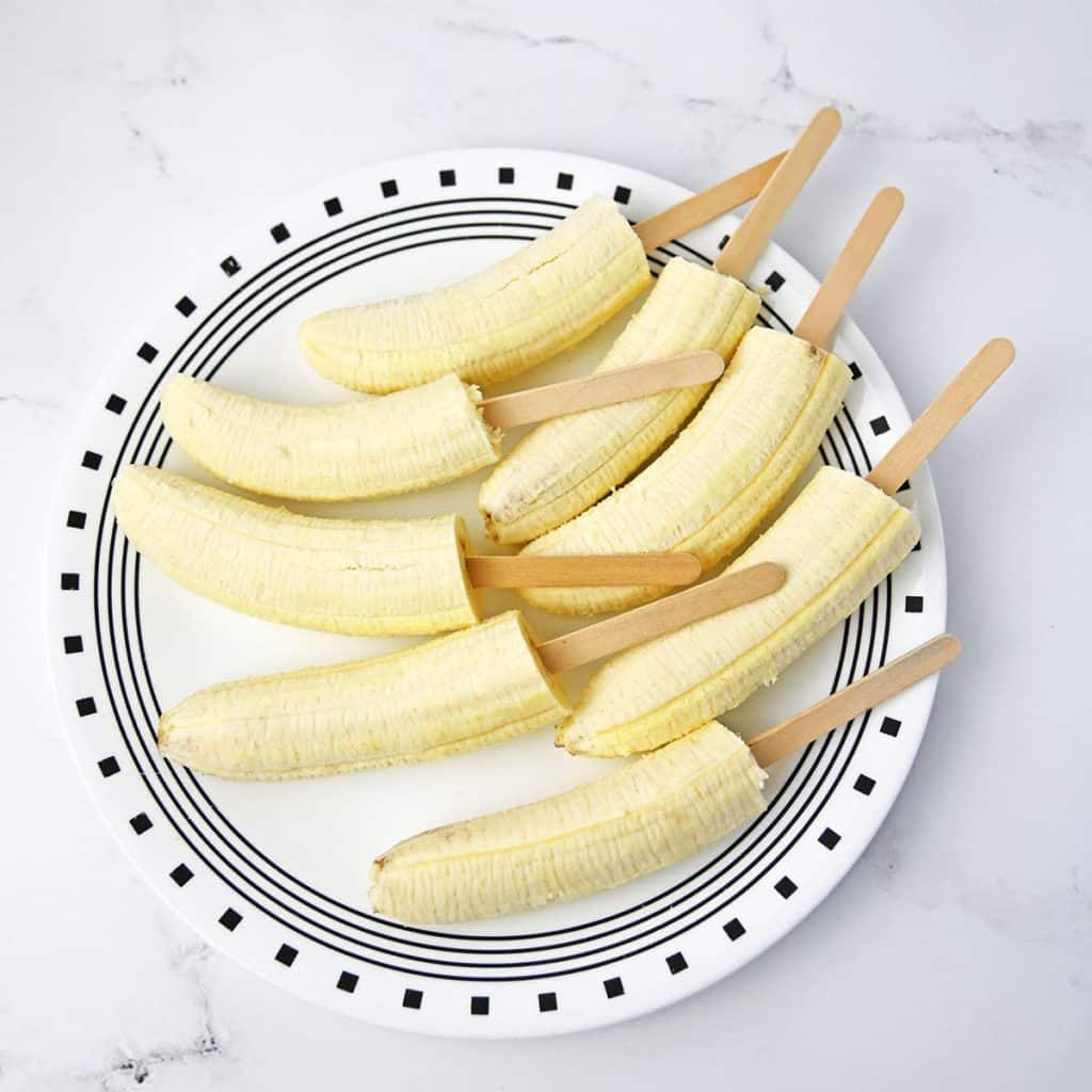 plate of bananas on popsicle sticks.