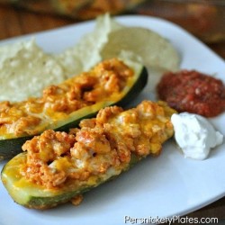 white plate with zucchini boats and sour cream & salsa