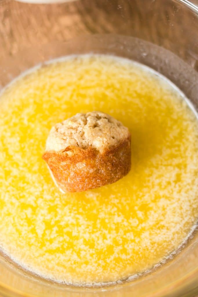 mini muffin in a bowl of melted butter.
