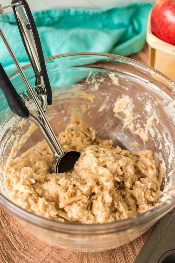 muffin batter in a mixing bowl with a cookie scoop.
