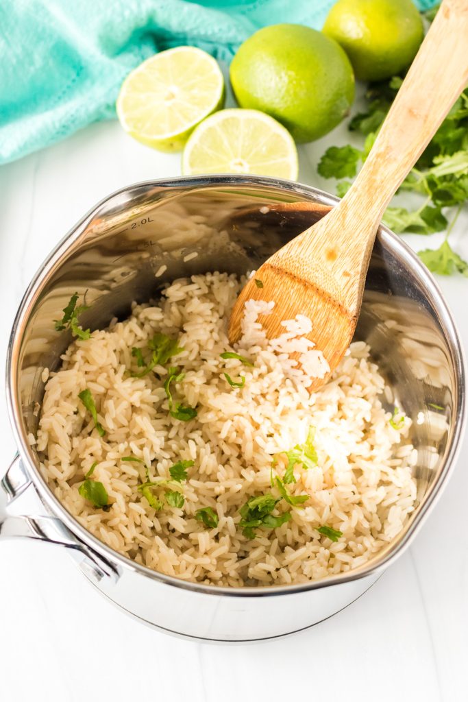 saucepan filled with rice with a wooden spoon.